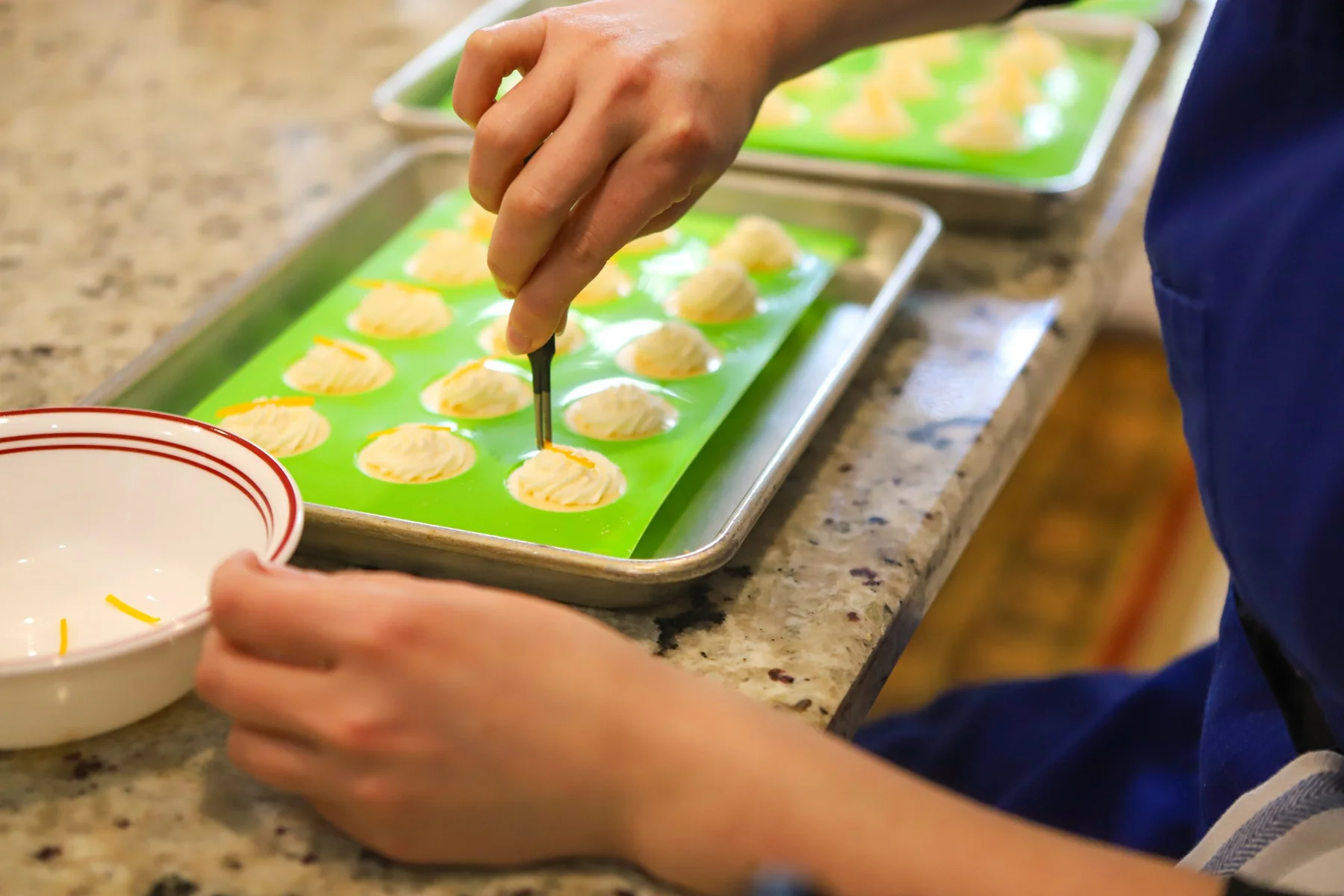 Hands preparing small sandwiches in the Tea Room kitchen.