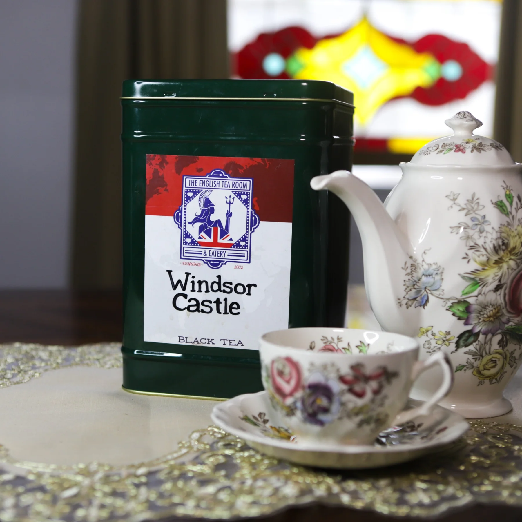 Windsor Castle tea tin beside a teacup and teapot.